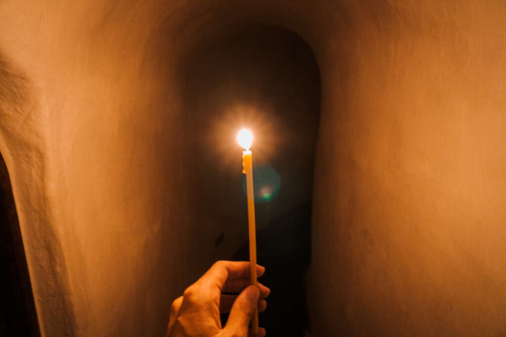 Я досліджую підземні тунелі Києво-Печерської лаври при свічках в Україні.