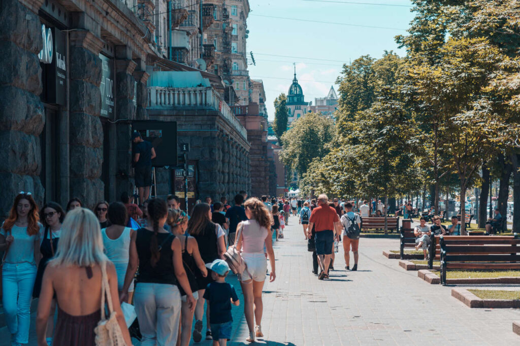 Люди йдуть вздовж торгової вулиці Хрещатик у літній день у Києві, Україна